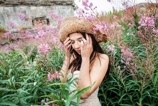 Portrait of a girl against background of nature and old concrete wall