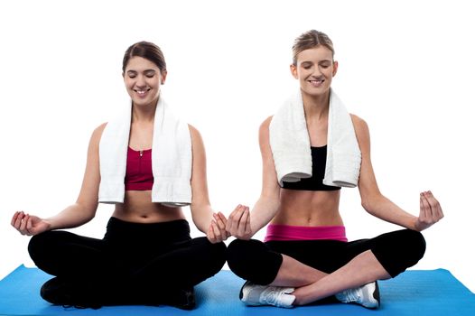 Beautiful young women doing meditation at fitness center