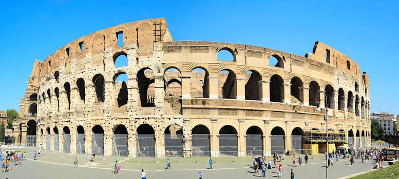 ROME, ITALY - SEPTEMBER 29, 2013: Tourists and local visiting famous Coliseum in Rome. Ancient landmark is under partial renovating. 