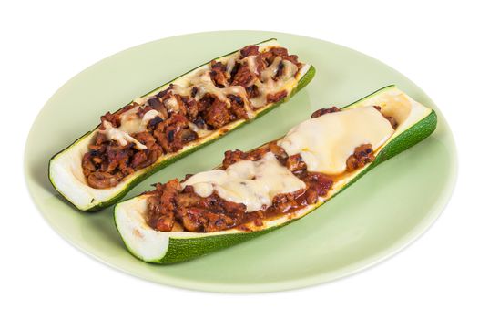 Zucchini halves stuffed with minced meat and vegetable on green plate