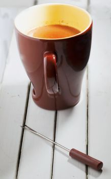 Chocolate cup over a white wooden background