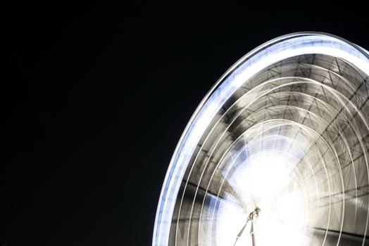 Fairy wheel in an amusement park during night time, taken at slow shutter.