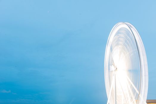 Fairy wheel in an amusement park during night time, taken at slow shutter.