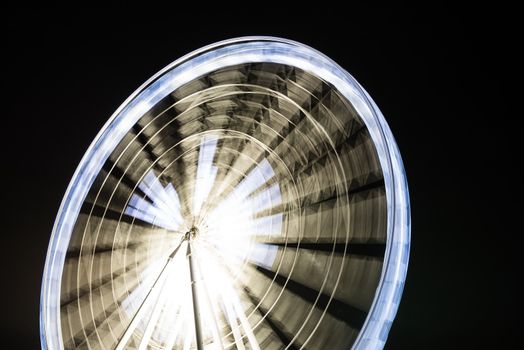 Fairy wheel in an amusement park during night time, taken at slow shutter.