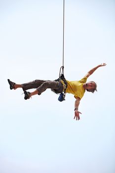 Happy rock climber hanging on a rope