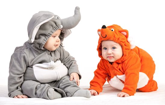 Two baby boys dressed in animal costumes over white background