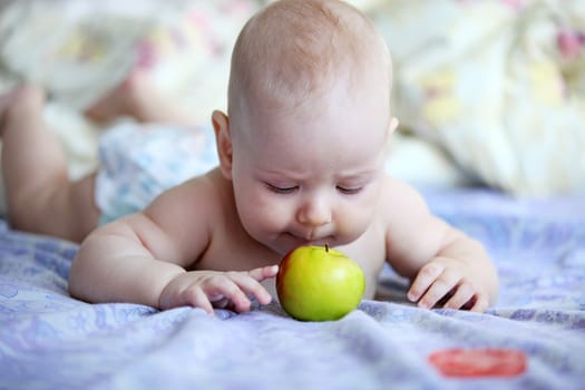 Little baby boy playing with apple indoors