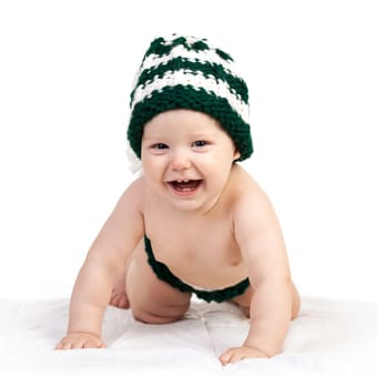 Happy baby boy in knitted hat crawling over white background