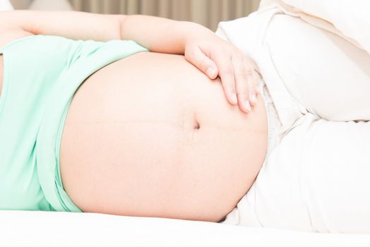 Young Thai pregnant woman sleeping in bed, taken in door