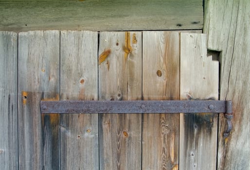 Old wooden door with rusty hinge