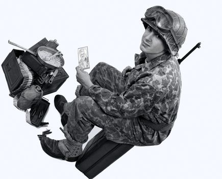 young American soldier in camouflage uniform shows a photograph