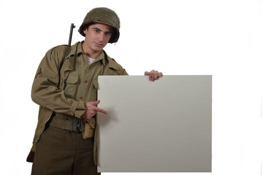 young American soldier with M1 helmet shows a signs