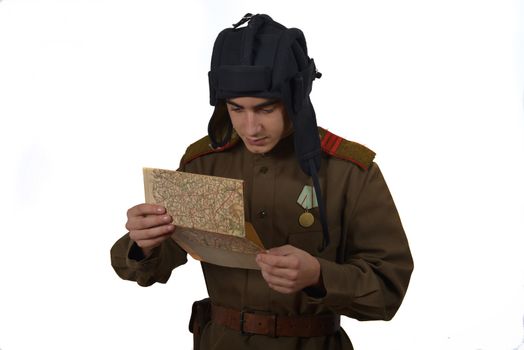 young Soviet tanker look at a map. he have a tanker helmet