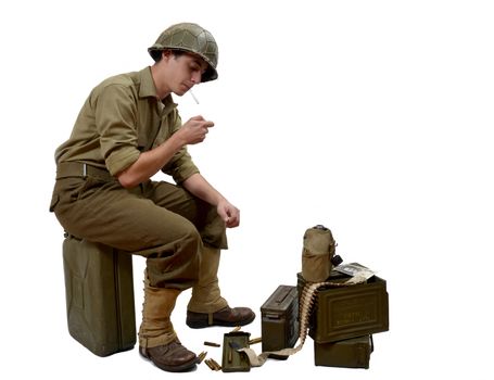 young American soldier sitting on a jerrycan lights a cigarette