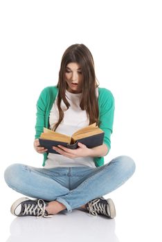 Young woman student sitting and reading a book. Isolated on white.