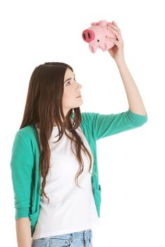 Young casual woman holding piggy-bank. Isolated on white.