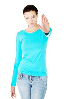 Beautiful casual woman showing stop gesture. Isolated on white.