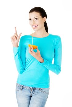 Beautiful young woman drinking juice from orange. Isolated on white.