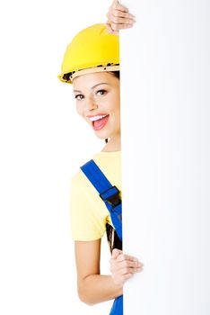 Beautiful young worker woman in protective clothes and helmet. Isolated on white.