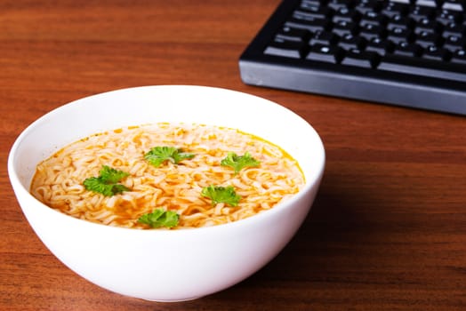 Bowl with soup and pasta lying on a table.