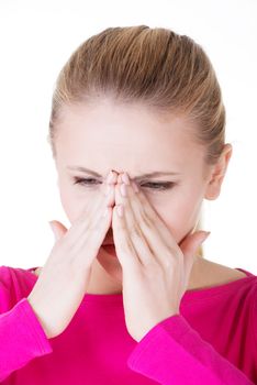 Young caucassian woman is having sinus pressure, touching her nose. Isolated on white.