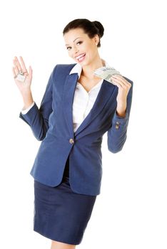 Beautiful young business woman with money and keys. Isolated on white.
