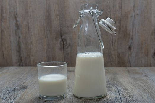 milk bottle with a glass on a wooden table