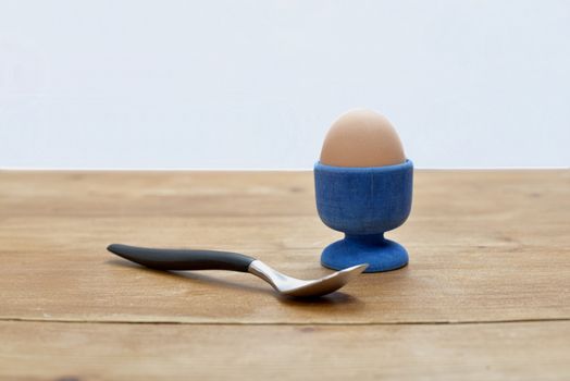 boiled egg in an egg cup with a small spoon