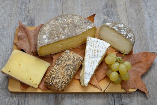 tray different french cheeses on a wooden tray