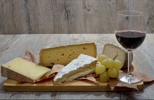 different french cheese tray with a glass of wine