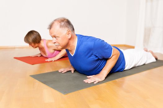 An image of some people doing yoga exercises