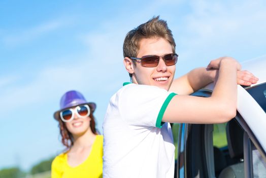 young man in sunglasses standing next to the car, the summer road trip