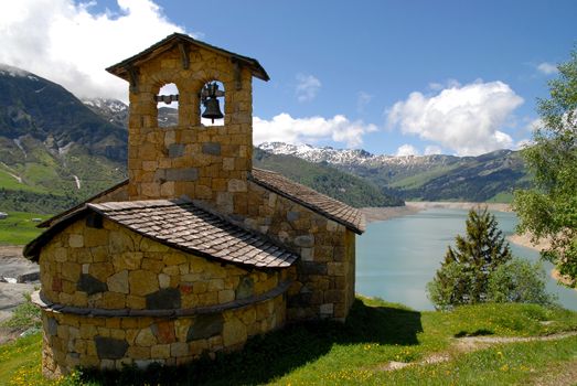 chapel in the mountains at the edge of an artificial lake