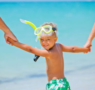 Summer vacation - Portrait of happy boy in face masks and snorkels, sea in background.