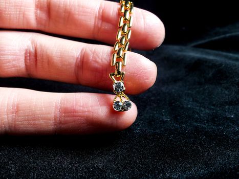 Golden jewelry with diamonds on fingers, isolated towards black background