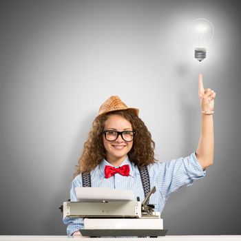 image of a young woman writer at the table with typewriter