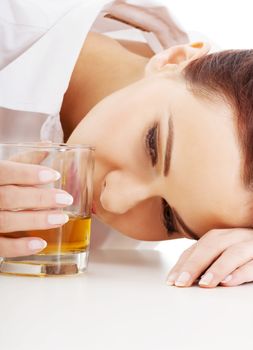 Young beautiful business woman with glass of whisky or rum. Isolated on white.