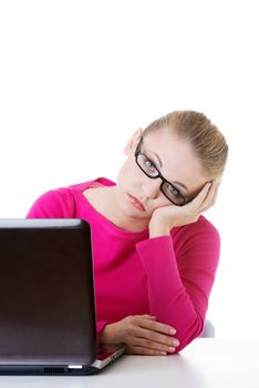 Bored, sad woman sitting in front of laptop. Isolated on white.