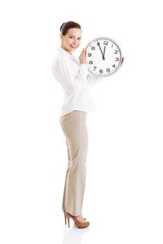 Young beautiful business woman holding clock. Isolated on white.