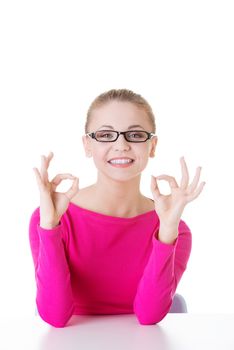 young casual woman student showin OK gesture. Isolated on white.