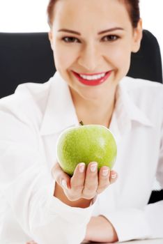 Young beautiful business woman holding an apple. Isolated on white.