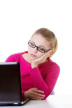 Bored, sad woman sitting in front of laptop. Isolated on white.