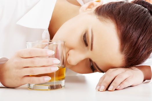 Young beautiful business woman with glass of whisky or rum. Isolated on white.