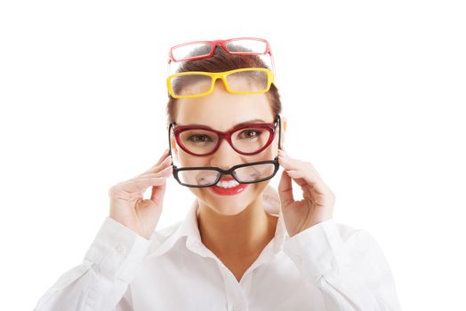 Beautiful woman wearing four different pairs of eyeglasses. Isolated on white.