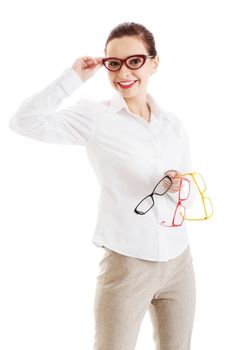 Beautiful woman in eyeglasses holding three different pair of eyeglasses. Isolated on white.