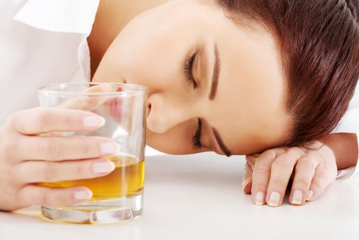 Young beautiful business woman with glass of whisky or rum. Isolated on white.