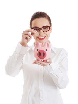 Beautiful business woman with coin and piggy- bank. Isolated on white.
