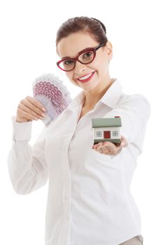 Beautiful business woman holding money and small house. Isolated on white.
