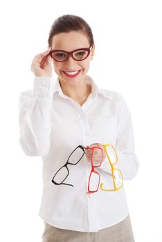 Beautiful woman in eyeglasses holding three different pair of eyeglasses. Isolated on white.