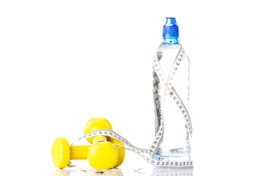 Bottle of water with measuring tape and weights. Isolated on white.